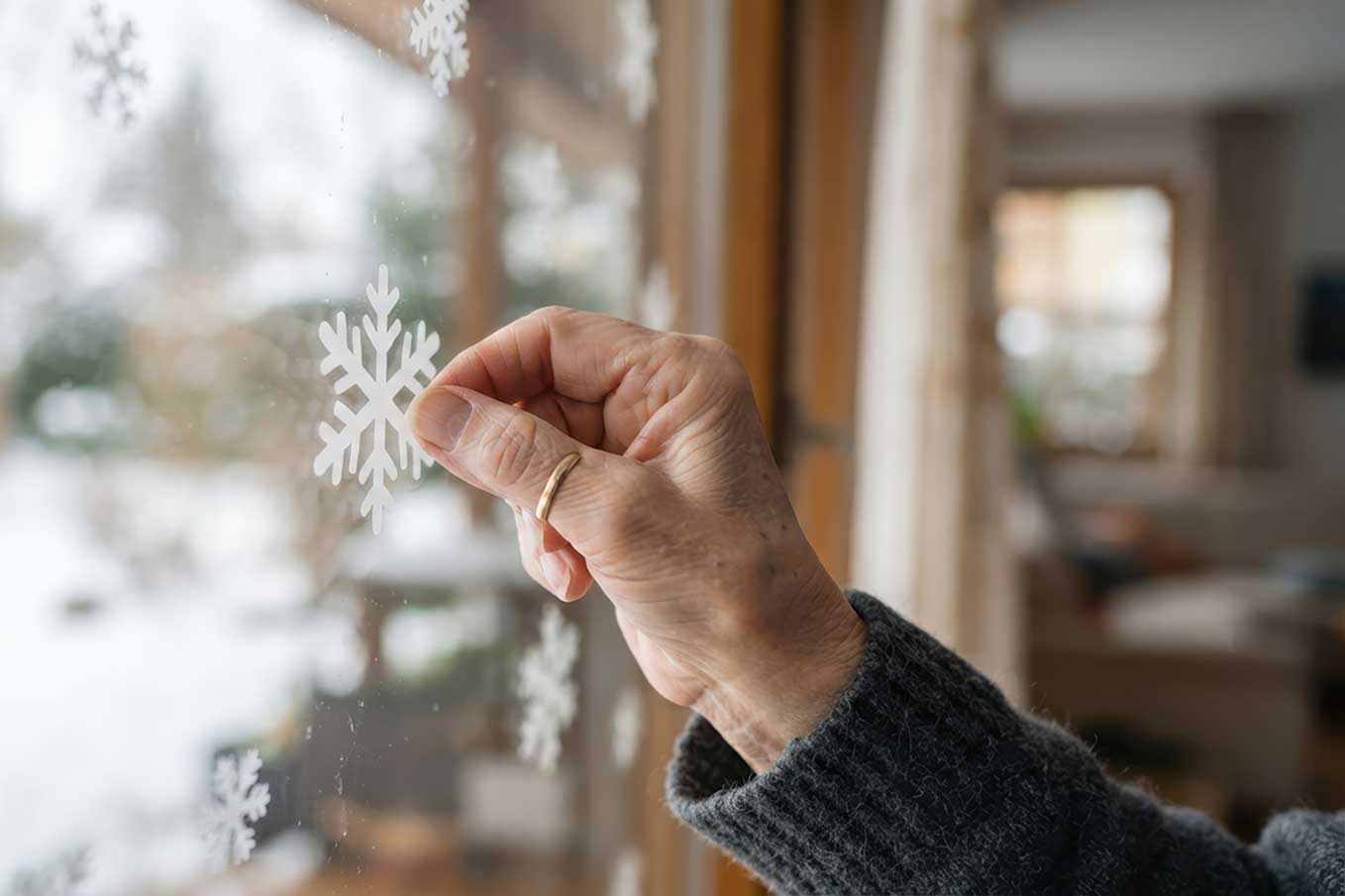 Senior placing snowflakes on a window